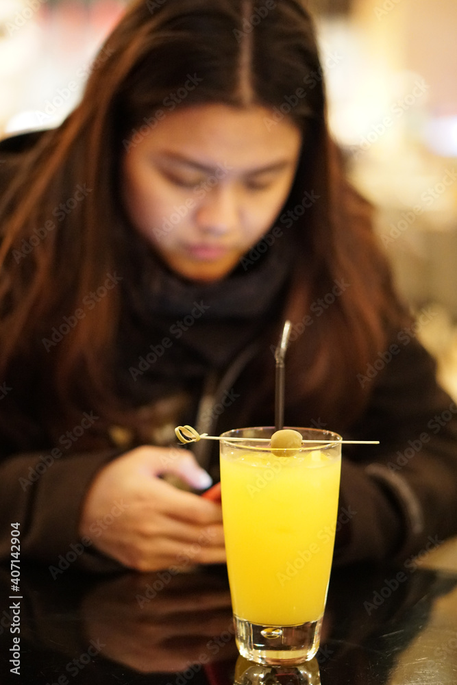 Orange welcome drink cocktail with Asian woman background Orange welcome drink cocktail with Asian woman background