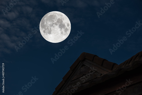 Full moon on the sky over roof house.