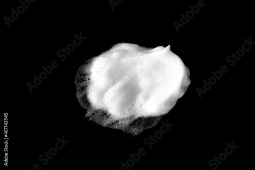 White soapy foam texture. Shampoo foam with bubbles.White facial foam creamy bubble soap sponge isolated on black background.