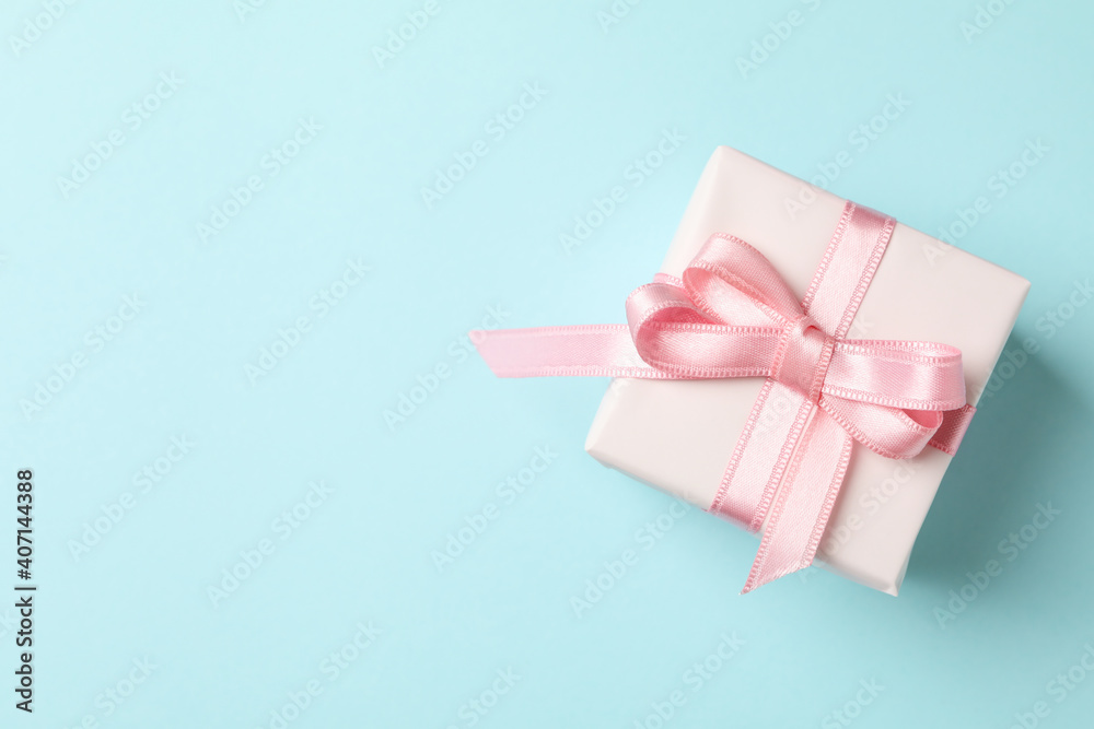 Gift box with pink ribbon on blue background