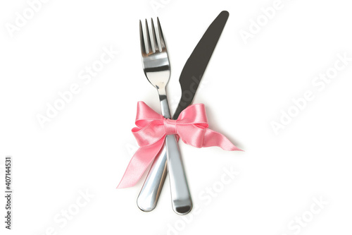 Cutlery with pink bow isolated on white background