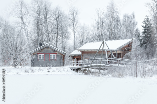 wooden cottages and footbridge on frozen lake shore © Michael Niessen