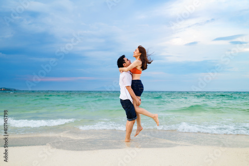 couple picking up and hugging on the sea beach at Koh MunNork Island, Rayong, Thailand