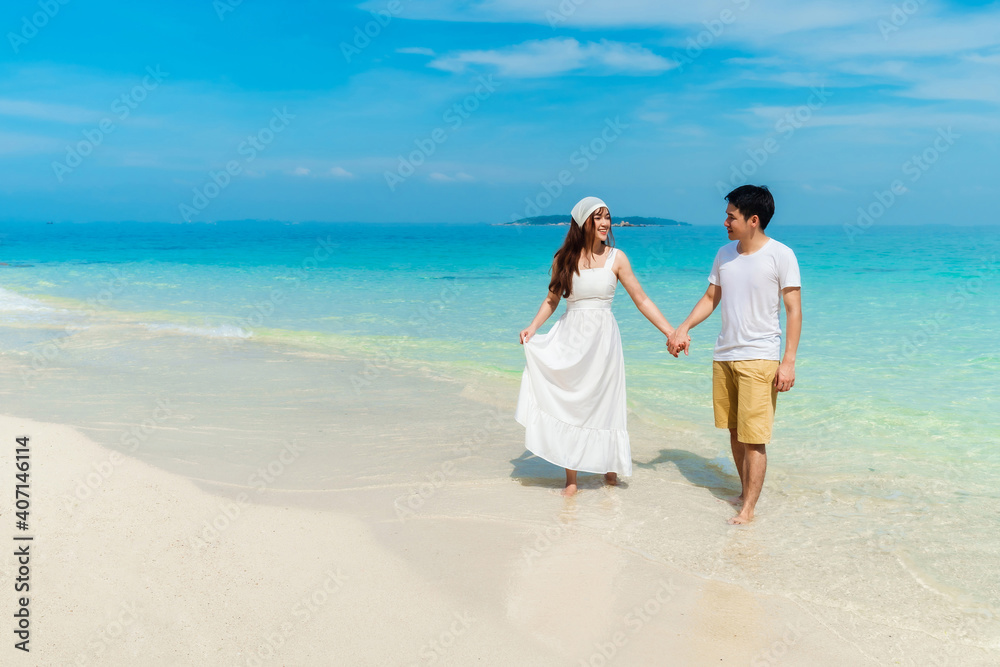 happy young couple walking on sea beach at Koh MunNork Island, Rayong, Thailand happy young couple walking on sea beach at Koh MunNork Island, Rayong, Thailand