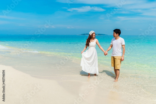 happy young couple walking on sea beach at Koh MunNork Island, Rayong, Thailand