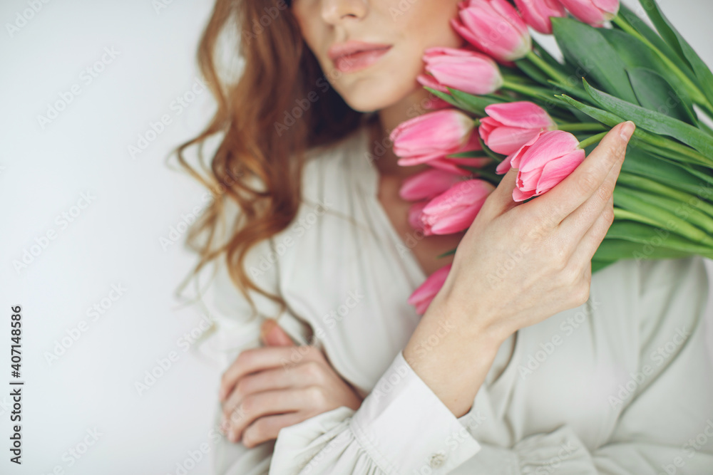 Happy woman holds tulips in her hands. Florist girl gathered a bouquet. Beautiful pink flowers. Blossom petal. . High quality photo.
