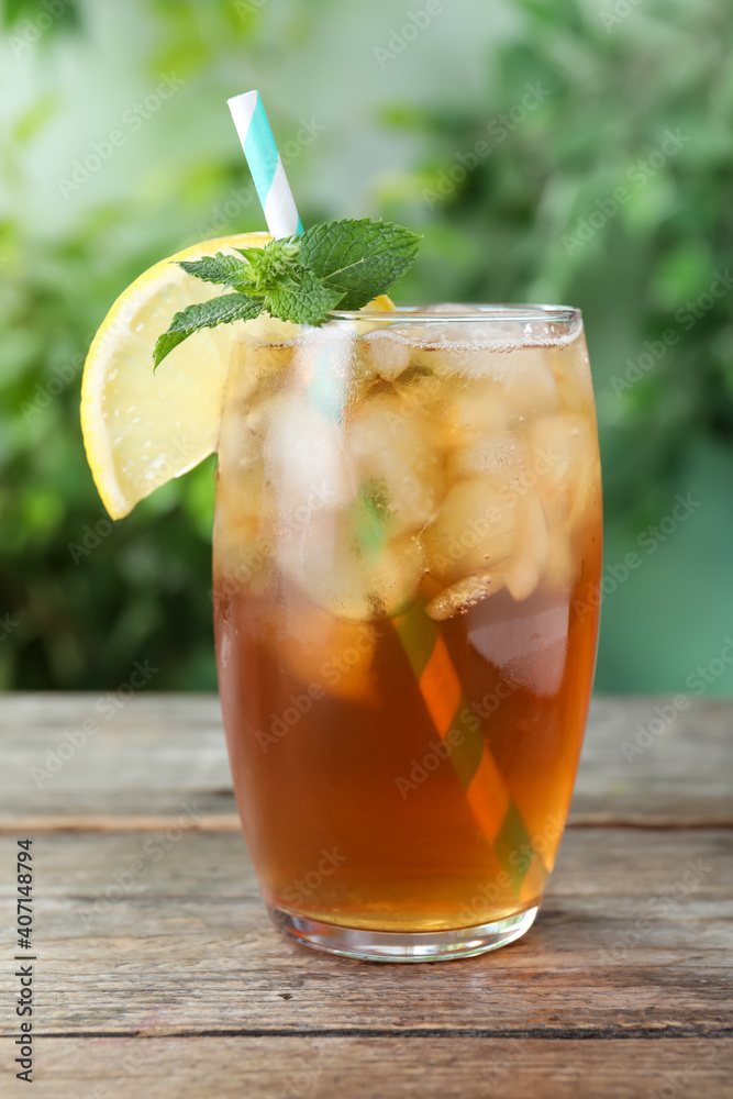 Delicious iced tea in glass on wooden table outdoors, closeup Delicious iced tea in glass on wooden table outdoors, closeup