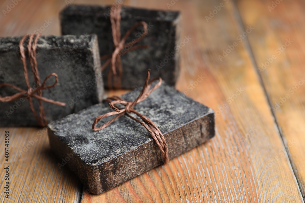 Natural tar soap on wooden table, closeup Natural tar soap on wooden table, closeup
