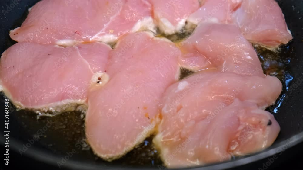 Poultry Fillet Fried in Oil in Frying Pan. Bubbles of Oil. Heat. Meat on Edge Turned White. Unfried Pink Fillet. Large Pieces. Roasting Meat at Home. Close-up. Cooking Food. Junk Food. Meat Dinner Poultry Fillet Fried in Oil in Frying Pan. Bubbles of Oil. Heat. Meat on Edge Turned White. Unfried Pink Fillet. Large Pieces. Roasting Meat at Home. Close-up. Cooking Food. Junk Food. Meat Dinner