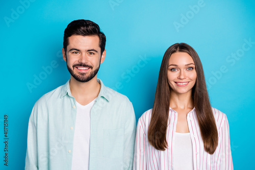 Photo of sweet adorable young lovers dressed casual shirts smiling isolated blue color background