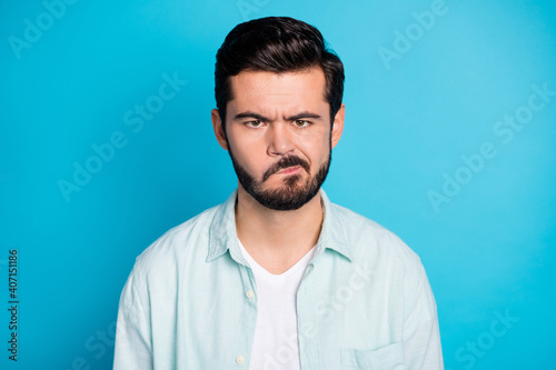 Photo of upset angry young man wear casual shirt bad mood conflict isolated on blue color background