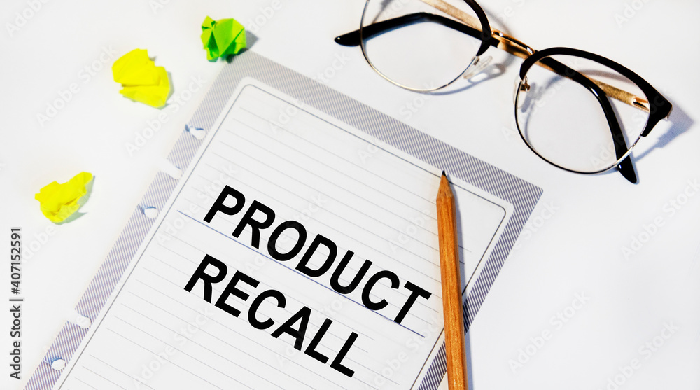 On a sheet from the diary text Product Recall, next to a pencil, glasses and sheets for notes. On a sheet from the diary text Product Recall, next to a pencil, glasses and sheets for notes.