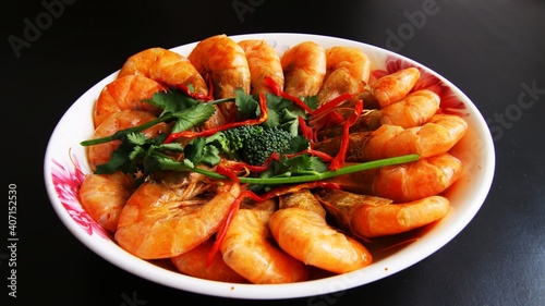 Chinese cuisine, shrimps garnished with green celery in a bowl