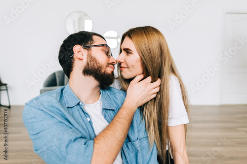 Loving young caucasian couple relaxing at home and kissing.