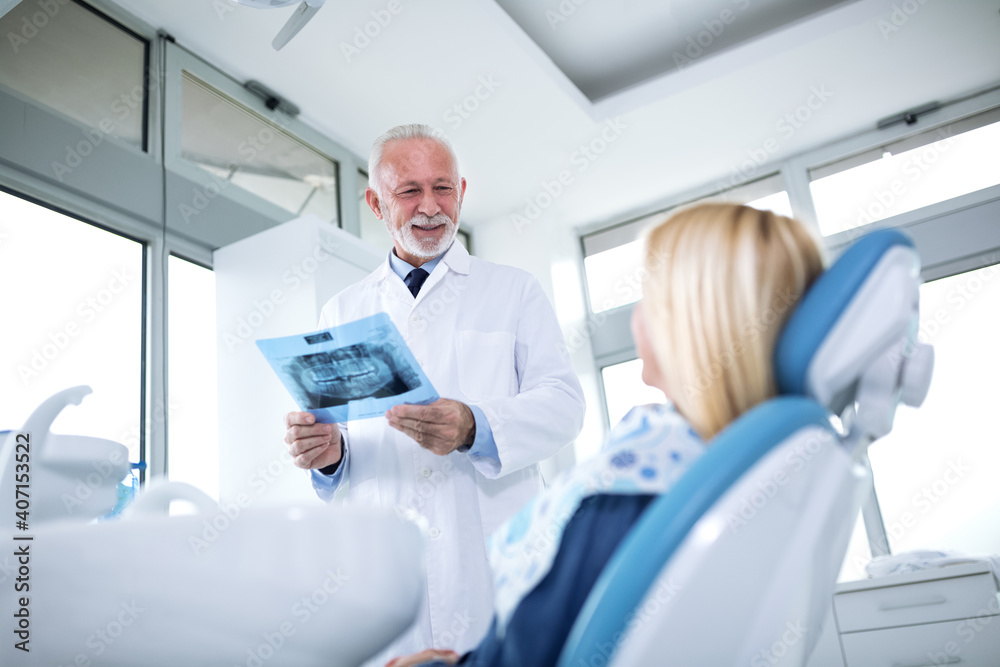 Dentist and patient looking at x-ray of teeth Dentist and patient looking at x-ray of teeth