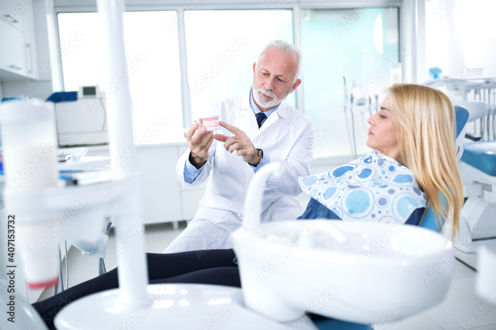 The dentist in the dentist's office shows the patient's appearance of her teeth The dentist in the dentist's office shows the patient's appearance of her teeth