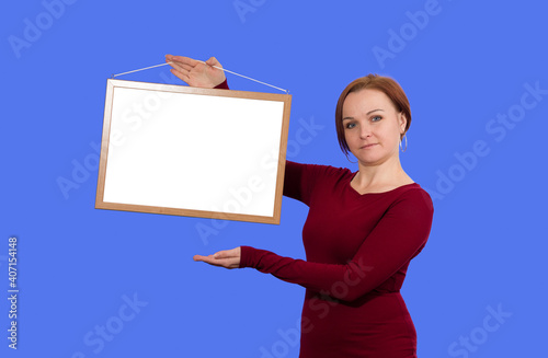 woman holding blank board on blue background
