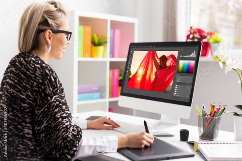 Woman editing photo on computer. Software interface is completely made up.