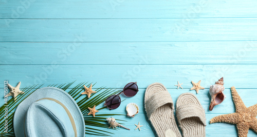 Beach accessories and space for text on light blue wooden background, flat lay. Banner design