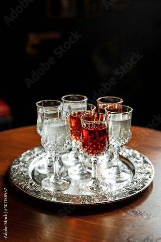 Different kinds of vermouth in small liqueur glasses on a silver tray