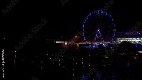 Ferris wheel at night. Blurry, colorful lights from an amusement park at night. Turning ferris wheel at night. © Vital9c
