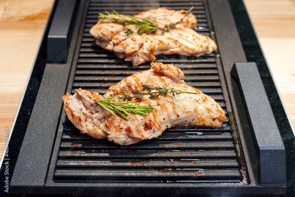 Chicken meat on grill. Spicy marinated chicken with herbs grilling on barbecue. Cooking on real kitchen Chicken meat on grill. Spicy marinated chicken with herbs grilling on barbecue. Cooking on real kitchen