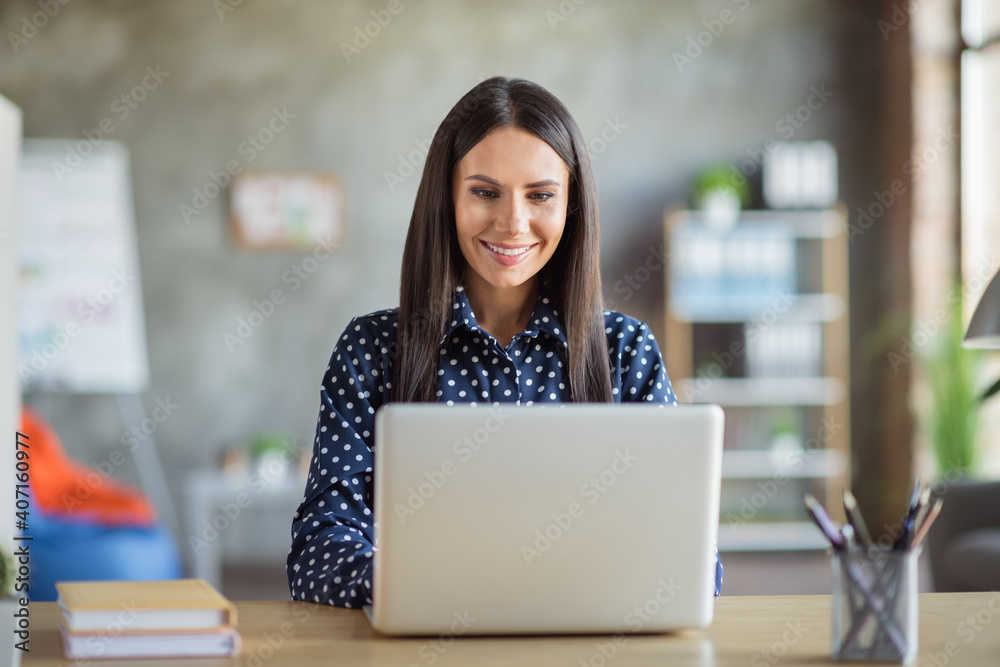 Fototapeta premium Photo of young attractive beautiful happy positive smiling cheerful businesswoman working in laptop at office workshop