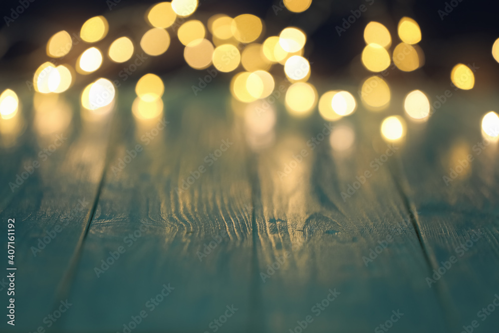 Blurred view of beautiful lights on wooden table, space for text Blurred view of beautiful lights on wooden table, space for text