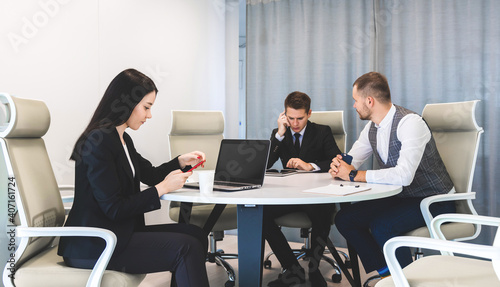 Group of young business people working and communicating while sitting at the office desk together with colleagues sitting. business meeting