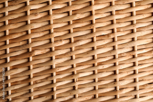 Handmade wicker basket made of natural material as background  closeup view