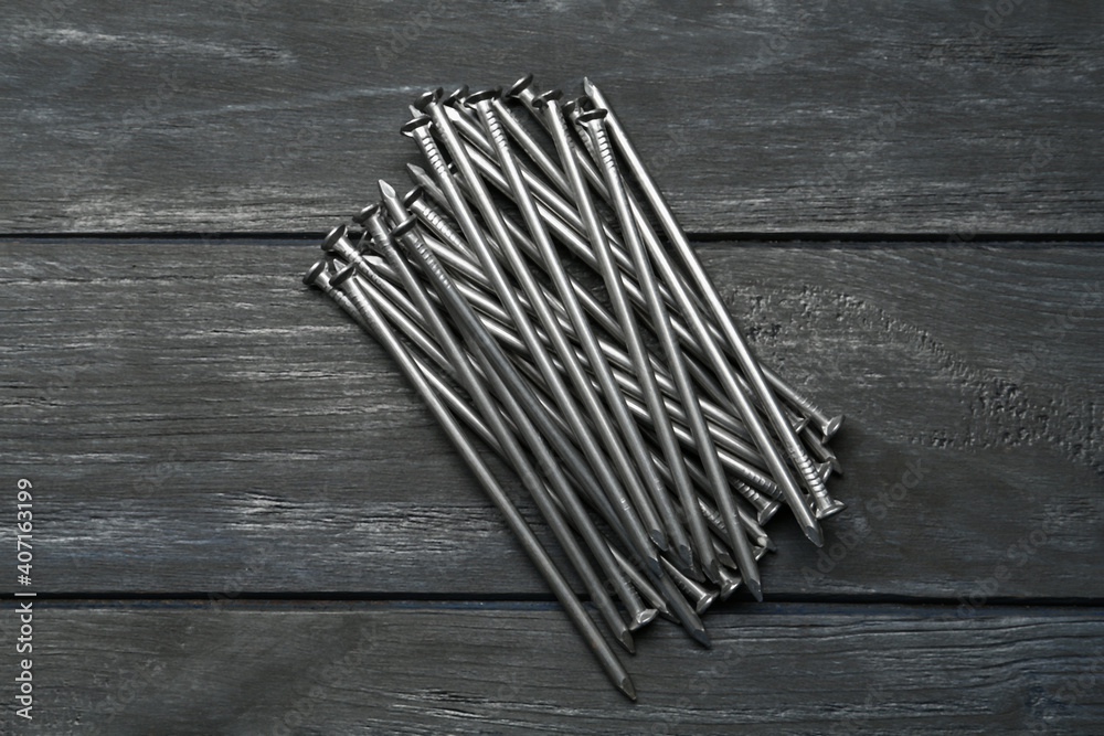 Pile of metal nails on grey wooden background, flat lay Pile of metal nails on grey wooden background, flat lay