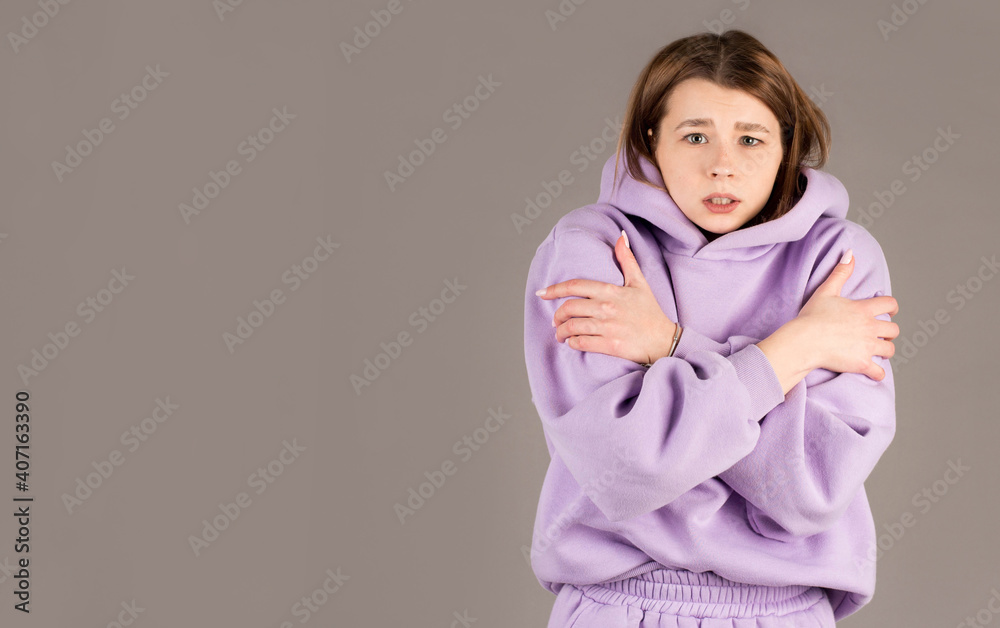 Half-length portrait of freezing woman , isolated on gray Half-length portrait of freezing woman , isolated on gray