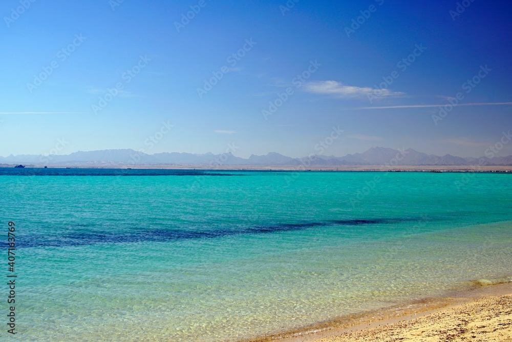 Landscapes of the red sea. Winter in Egypt. January in Africa. Azure water and sandy beach. Mountains on the horizon