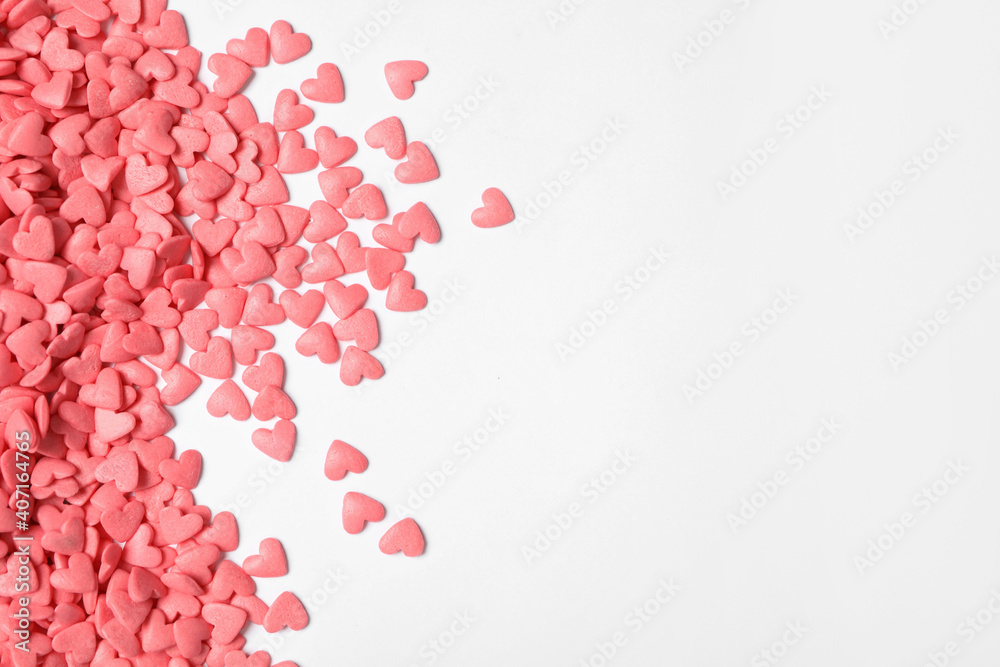 Pink heart shaped sprinkles on white background, flat lay. Space for text
