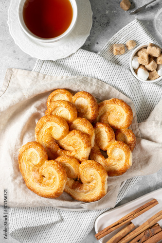 Obraz na płótnie Puff. Flaky sugar Palmiers cookies in a ceramic plate on a light background. Sweet homemade cakes w salonie
