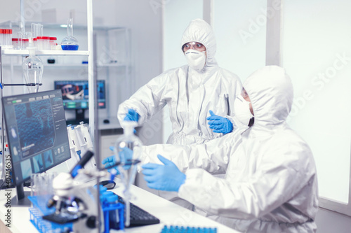 Excited scientists after discovering coronavirus vaccine during work in modern laboratory. Team of doctors working with various bacteria and tissue, pharmaceutical research for antibiotics against