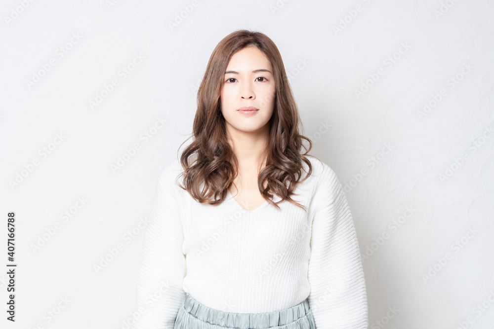 白い壁の前に立つ若い女性 白い壁の前に立つ若い女性