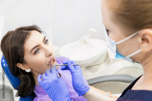 Dentistry concept. Professional dental services and modern equipment without pain. The doctor consults and treats the young woman  conducts an examination and draws up a treatment plan