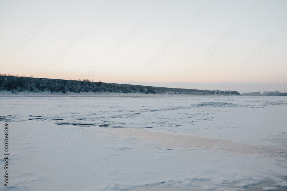 Landscape with frozen water, ice and snow on the  river during winter.