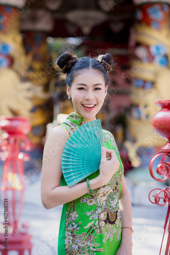 Action portrait beautiful Asian girl wearing Cheongsam green dress. the celebration of something in a joyful and exuberant way. Festivities and Celebration concept