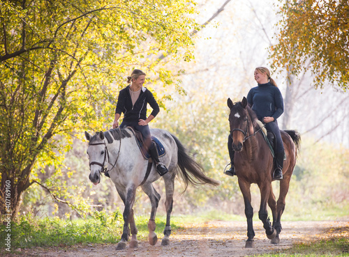Two girls ride beautiful  horses © Dusan Kostic