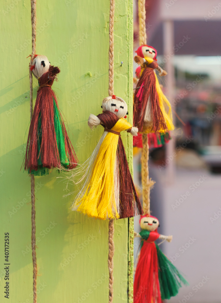 Vibrant multicolor jute dolls, used as wall hanging puppets in a retail display for sale at a handicraft fair in Kolkata.