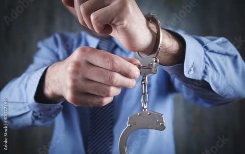 Man unlocking handcuffs by key. Freedom concept
