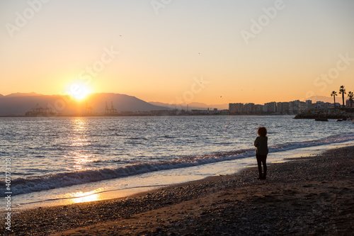 Woman thinking and looking at the sea during sunset