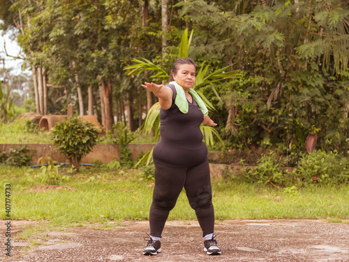 Middle aged obese women exercise in the park to maintain good health,lose weight keep fit.