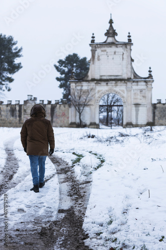 person on a road with snow and castle in the background © Semart