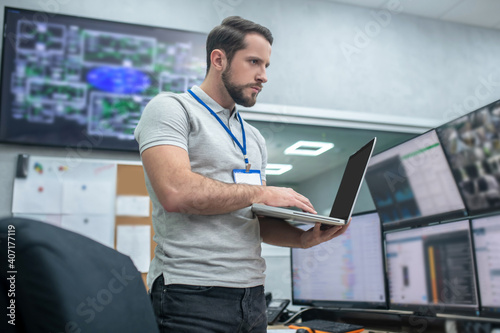 Serious man with laptop in specially equipped office photo