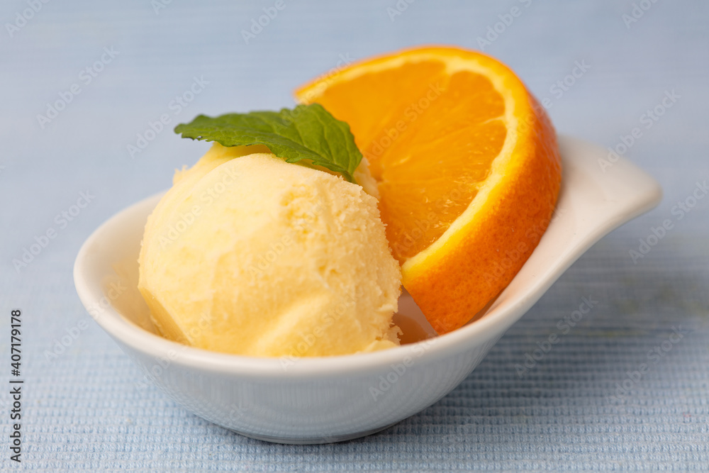 Frische Kugel Orangensorbet mit einer Scheibe Orange Frische Kugel Orangensorbet mit einer Scheibe Orange