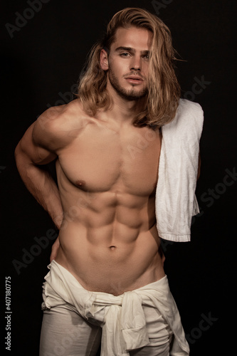 Sexy sport muscle strongface blond guy with long hair in white underwear on black isolated  font background photo