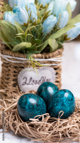Dyed eggs in dark tidewater green tones. Easter festive background, open card, eggs close-up. Table setting for the Easter holiday. Christ is Risen Easter holiday.